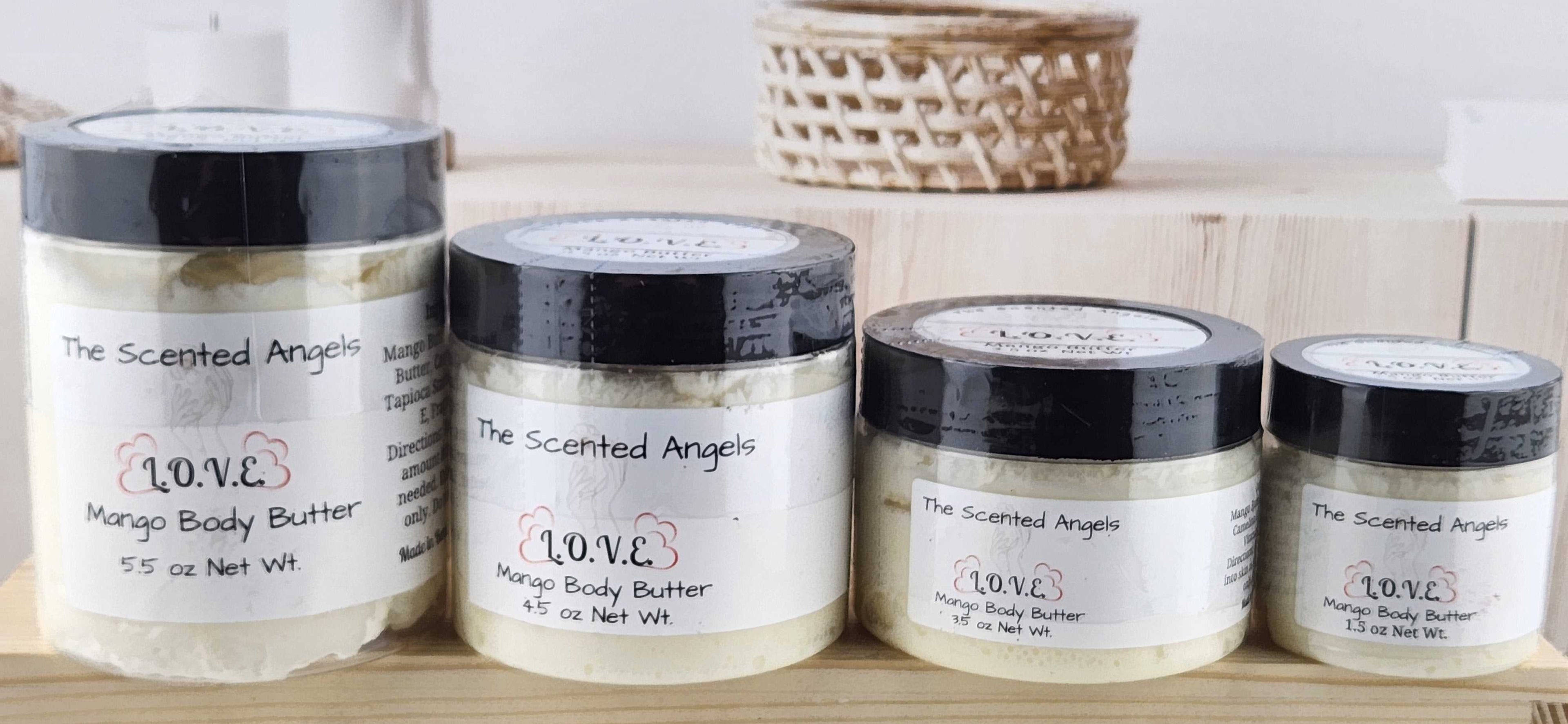 Four jars of Mango Body Butter by The Scattered Angel on a wooden surface.