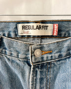 Close-up of the waistband of Levi's Regular Fit 505 jeans, showing the white and red brand labels, a silver metal button, and light blue denim fabric.