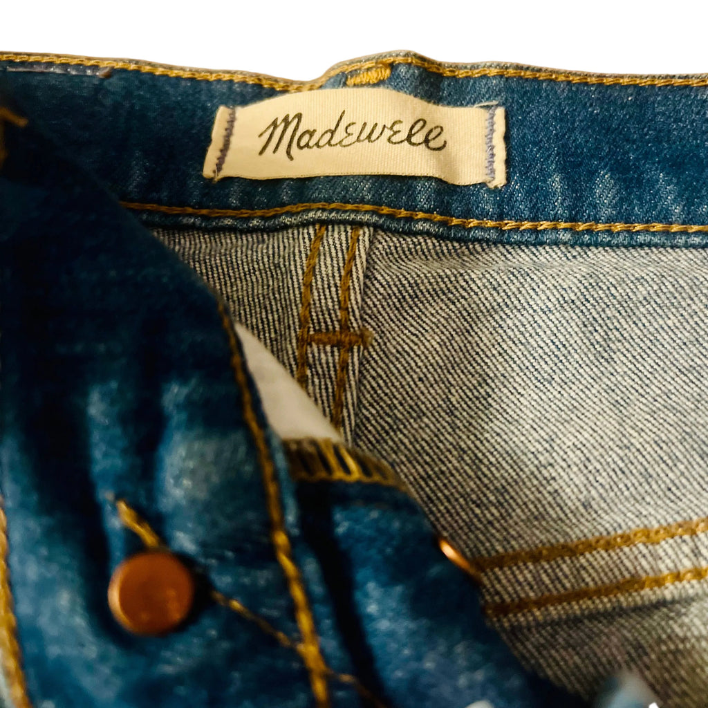 Close-up of a denim garment with a Madewell label on a white background