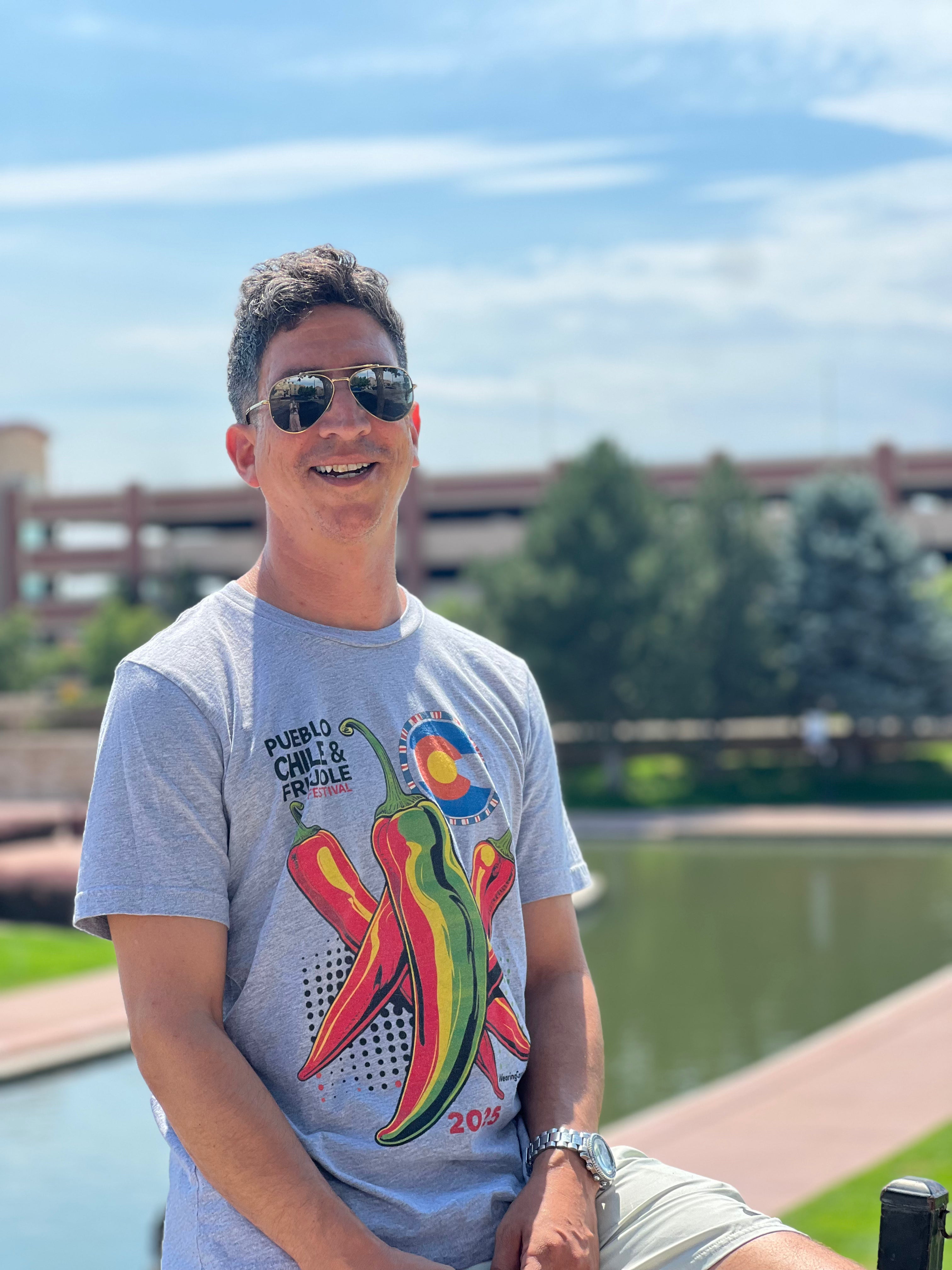 Man wearing a gray t-shirt with chili pepper design outdoors