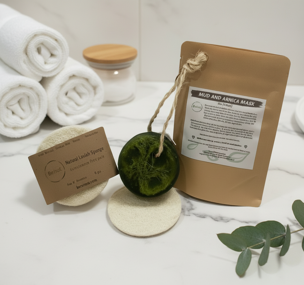 Mud and Arnica Mask packaging with a green sponge and sandalwood scrubber on a white background