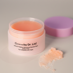 Jar of makeup remover balm with a purple lid on a neutral background