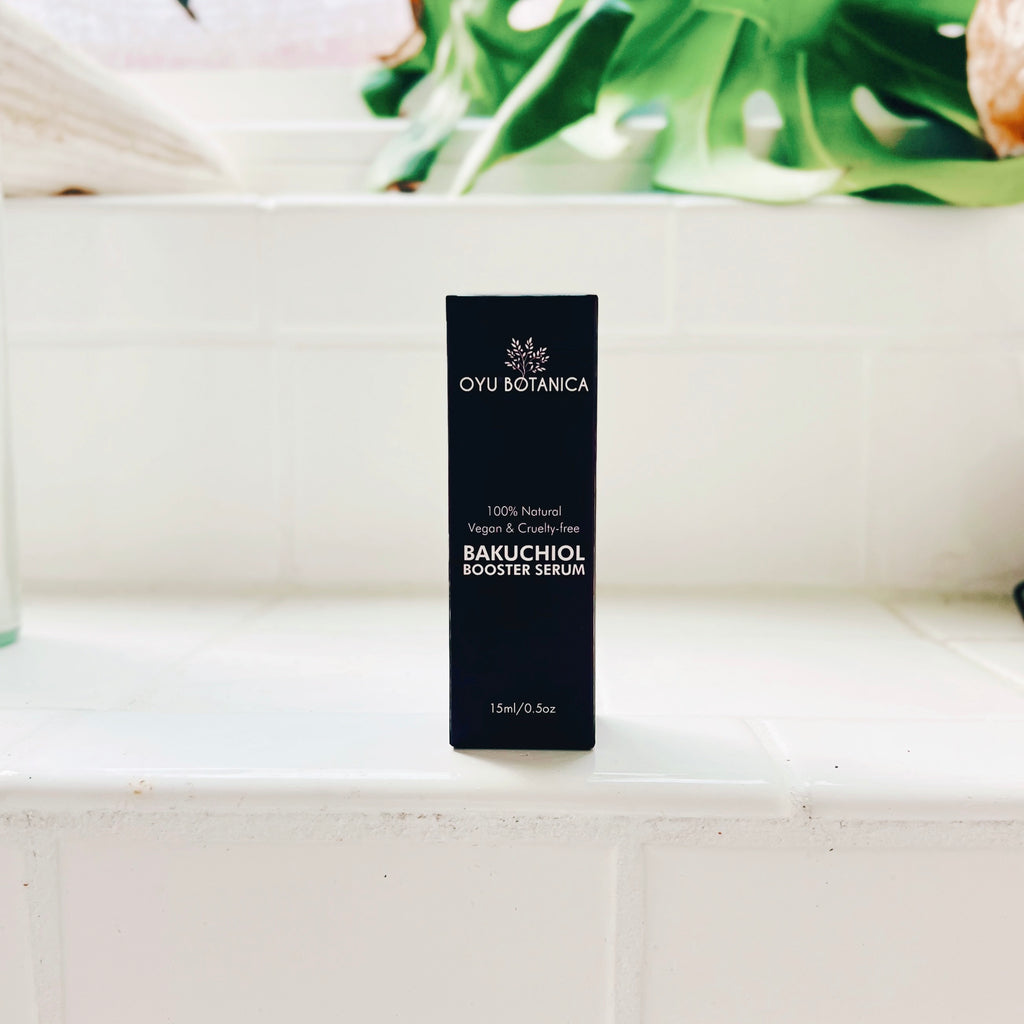 Oyu Botanica Bakuchiol Booster Serum box on a white surface with greenery in the background