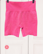 Pink shorts hanging on a white background