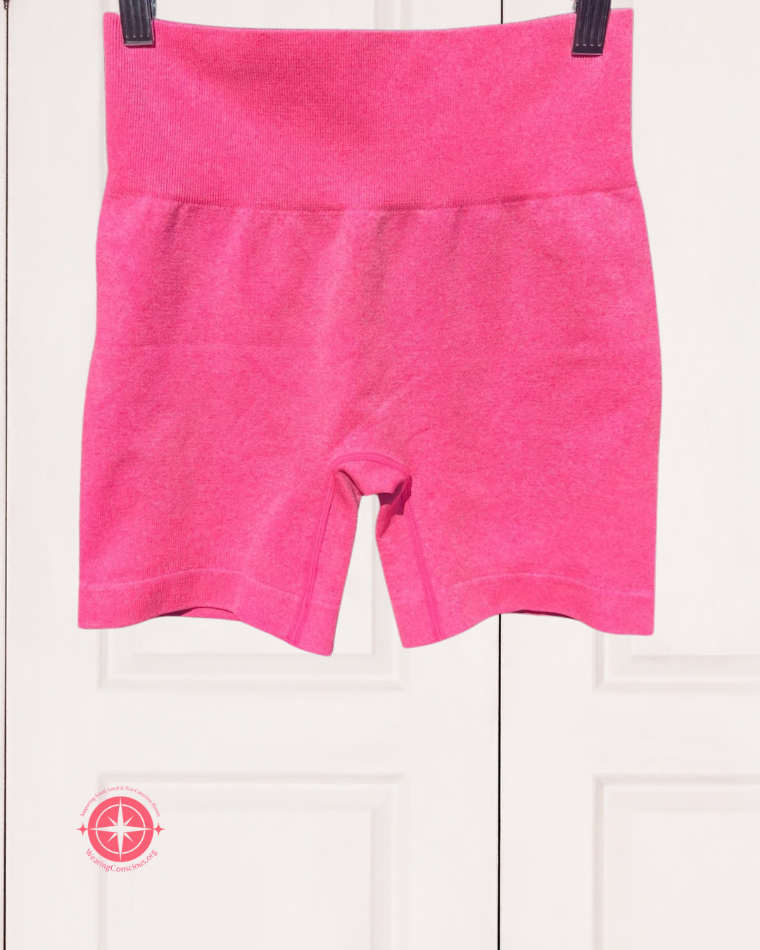 Pink shorts hanging on a white background