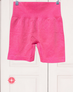 Pink shorts hanging on a white background