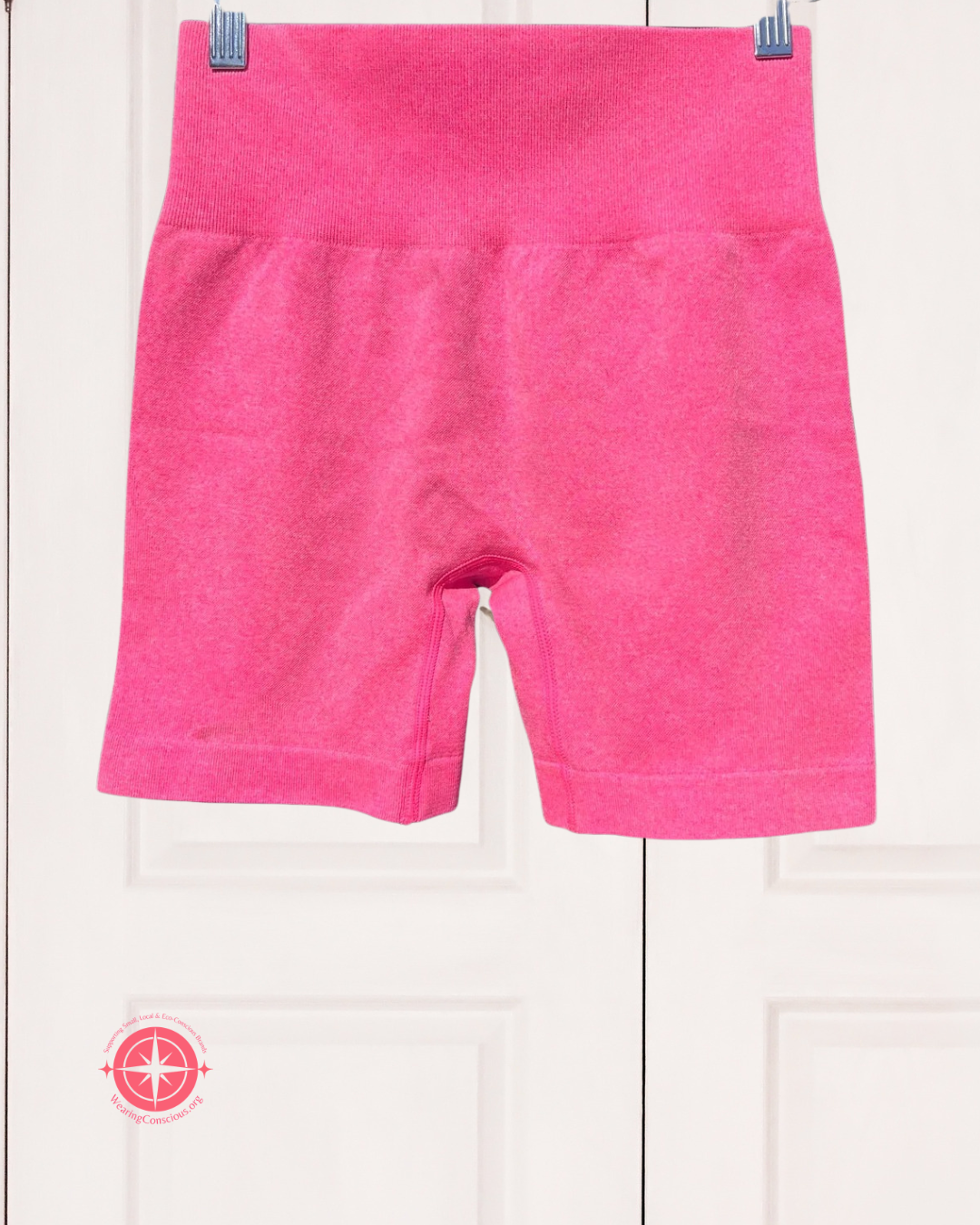 Pink shorts hanging on a white background