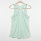 Light green tank top on a textured brown background