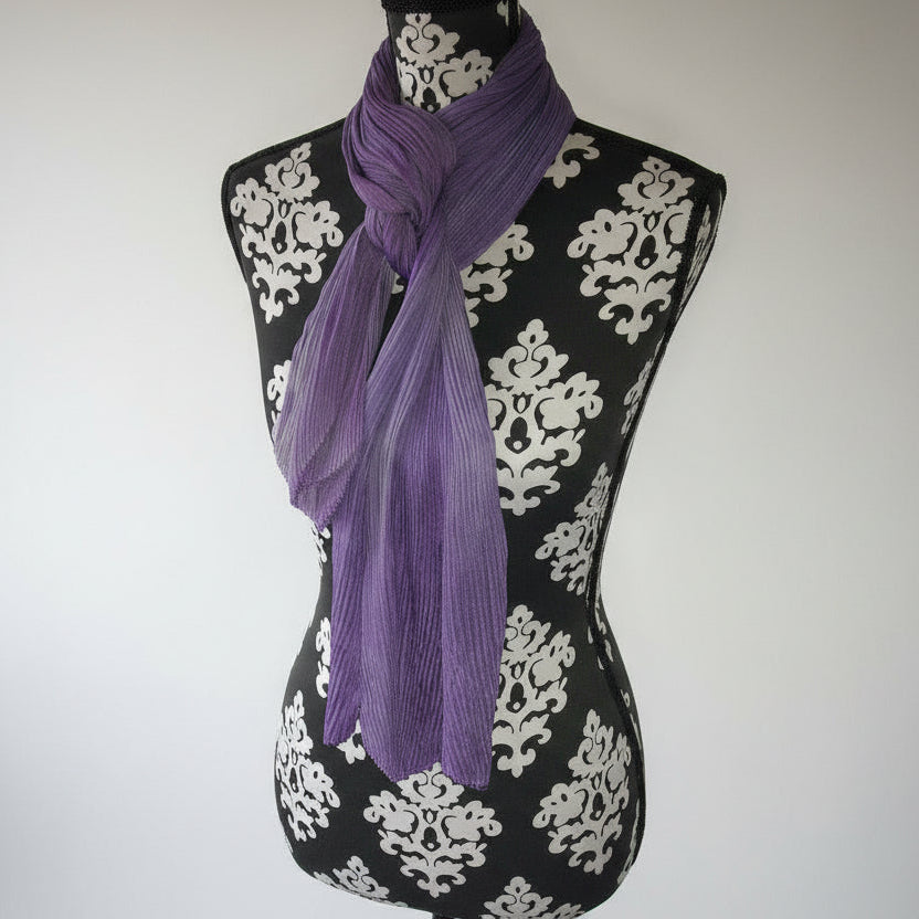 Purple scarf draped over a black and white patterned surface