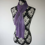 Purple scarf draped over a black and white patterned surface