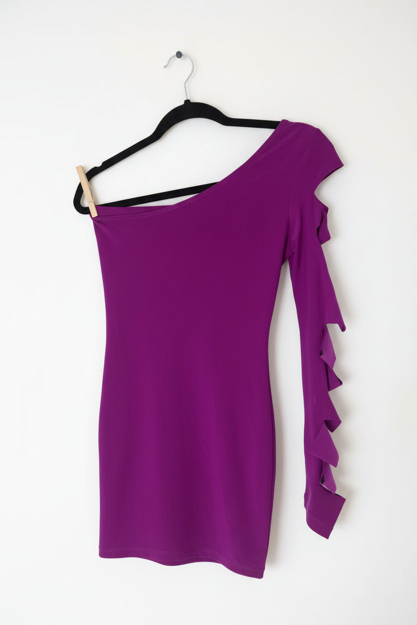 Purple one-shoulder dress with ruffle detail on a hanger against a white background