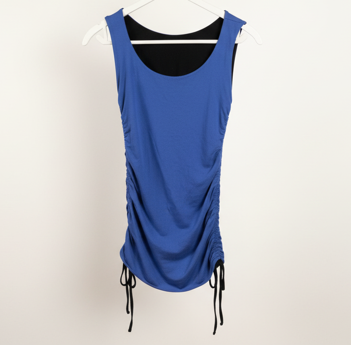 Purple reversible dress on a hanger against a white wall.