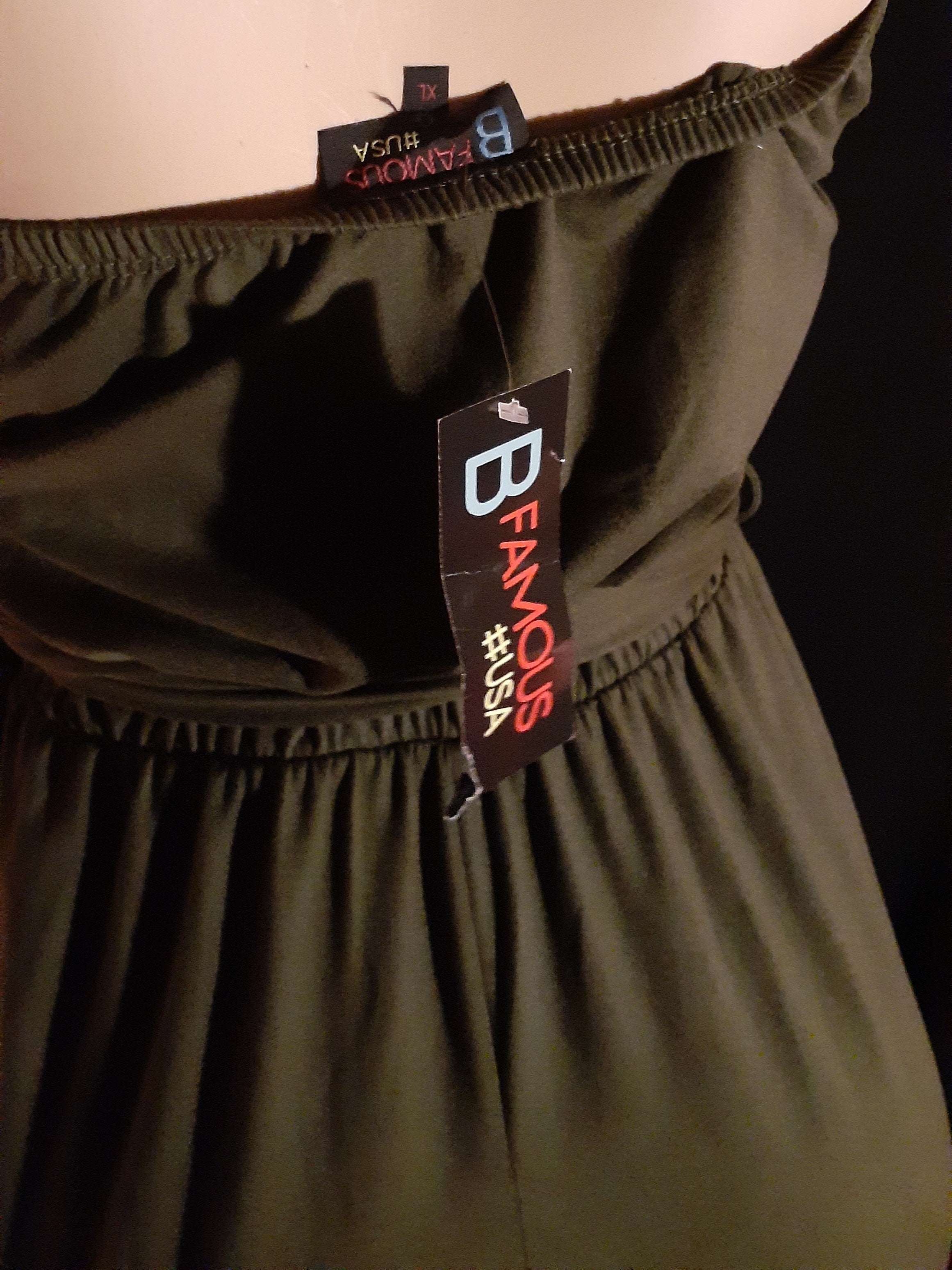 Brown dress with a 'B Famous' tag on a black background