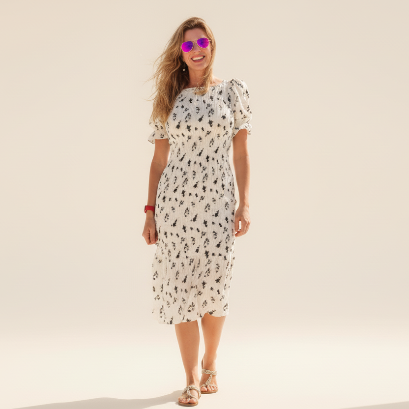 Woman wearing a white floral dress on a plain background