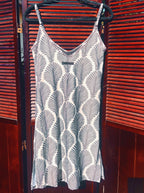 White patterned dress on a hanger against a red wooden background