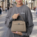 Woman holding a beige handbag 