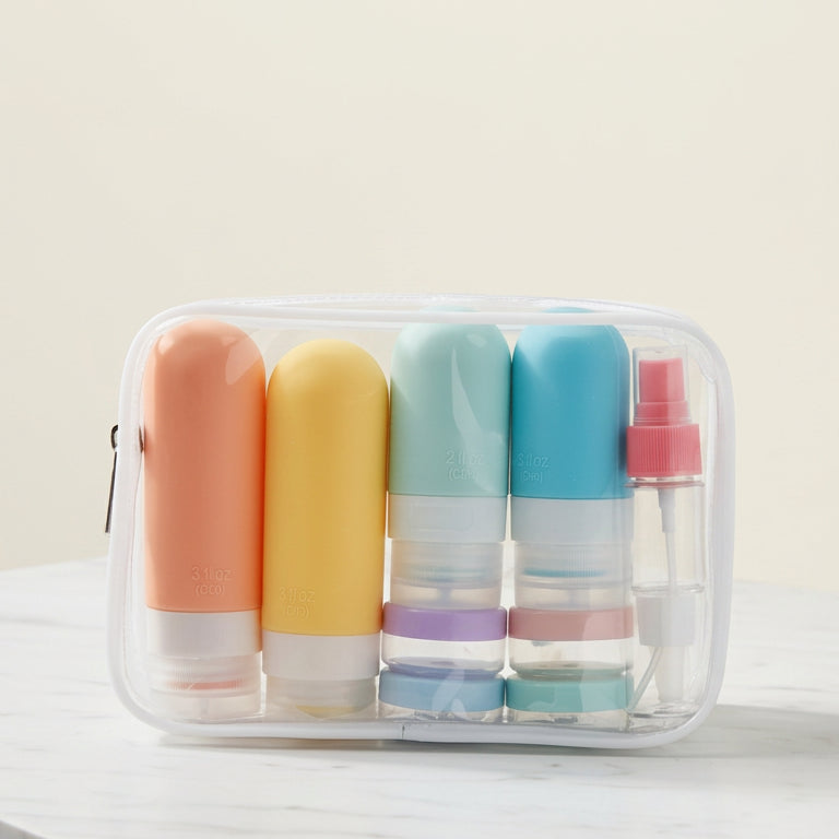 Set of colorful travel-sized bottles in a clear container on a bathroom counter.