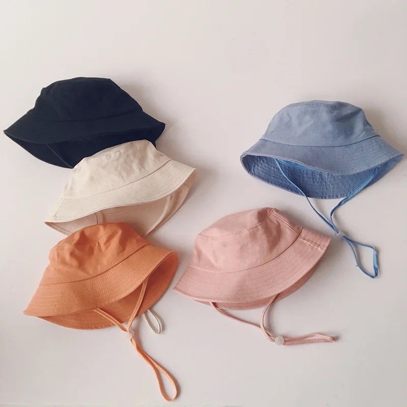 Five colorful bucket hats on a light gray background