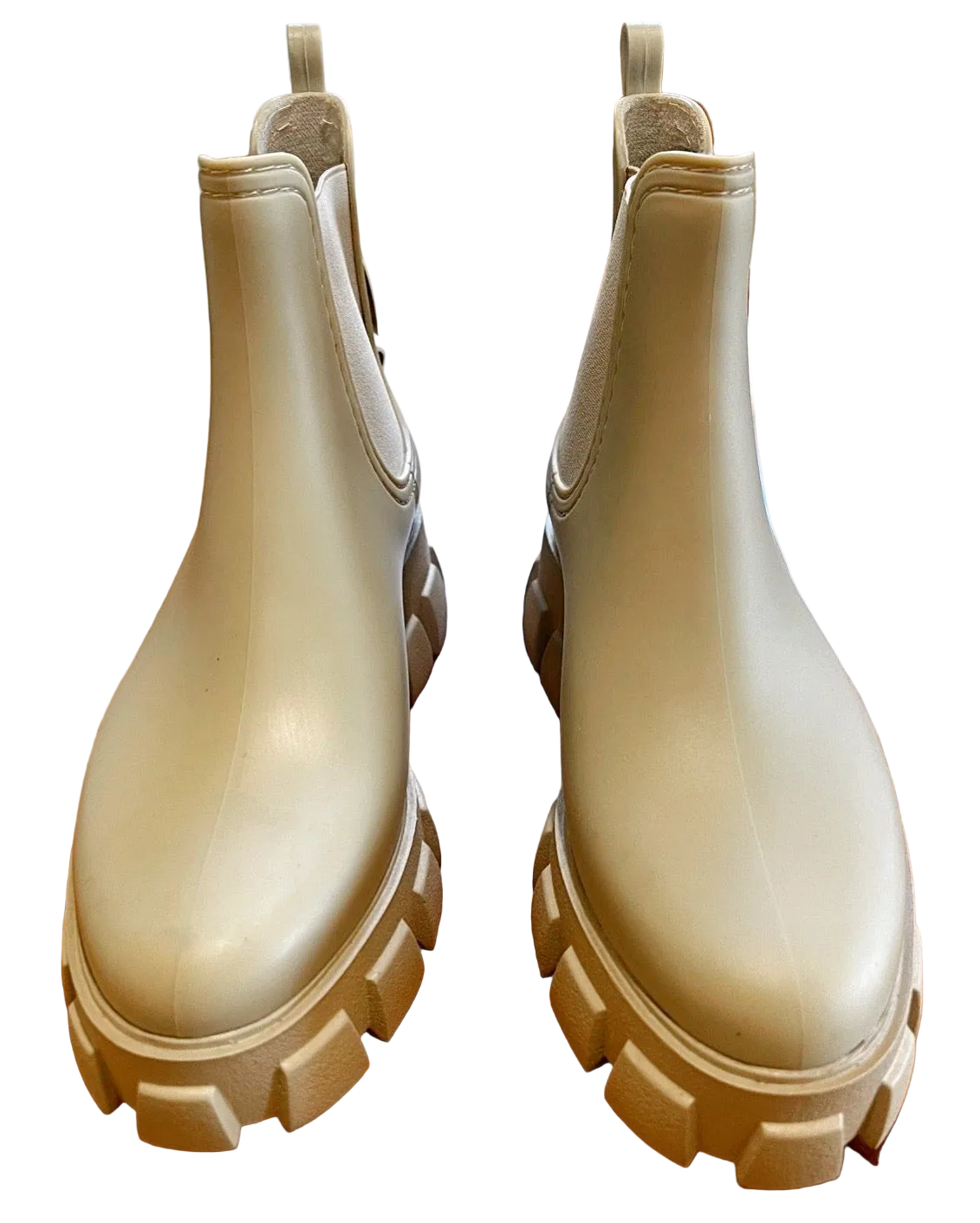 A pair of glossy beige Chelsea-style rain boots with chunky lug soles, shown from a top-down view on a white background.