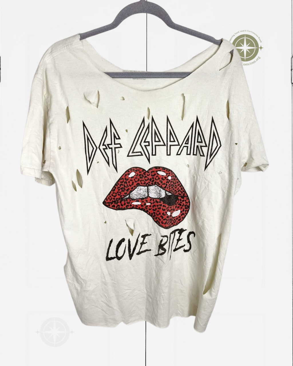 A distressed off-white short-sleeve t-shirt hanging on a dark hanger against a white background. The shirt features a graphic print of the band Def Leppard with their logo, red lips with leopard print, and the text 'LOVE BITES'.