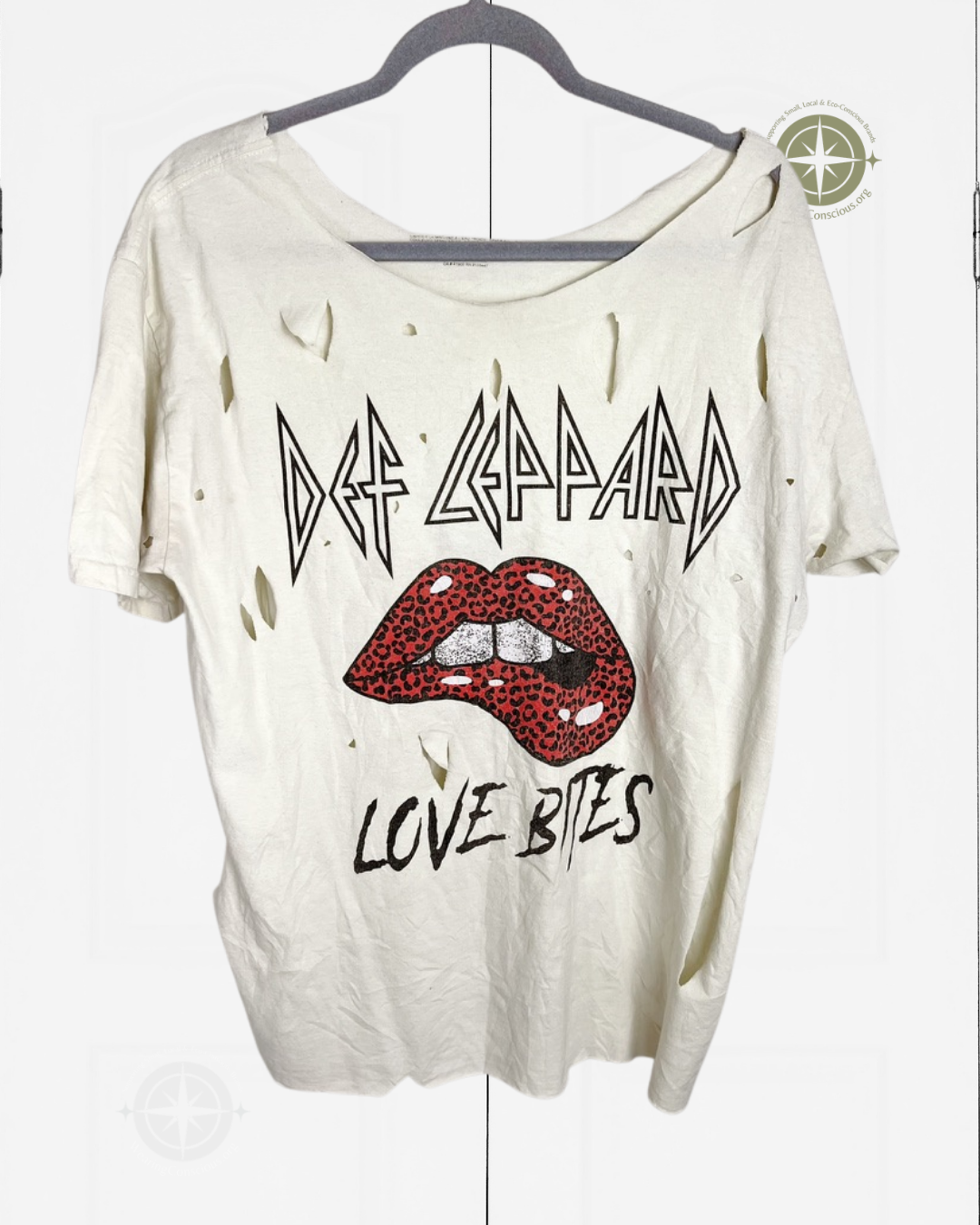 A distressed off-white short-sleeve t-shirt hanging on a dark hanger against a white background. The shirt features a graphic print of the band Def Leppard with their logo, red lips with leopard print, and the text 'LOVE BITES'.