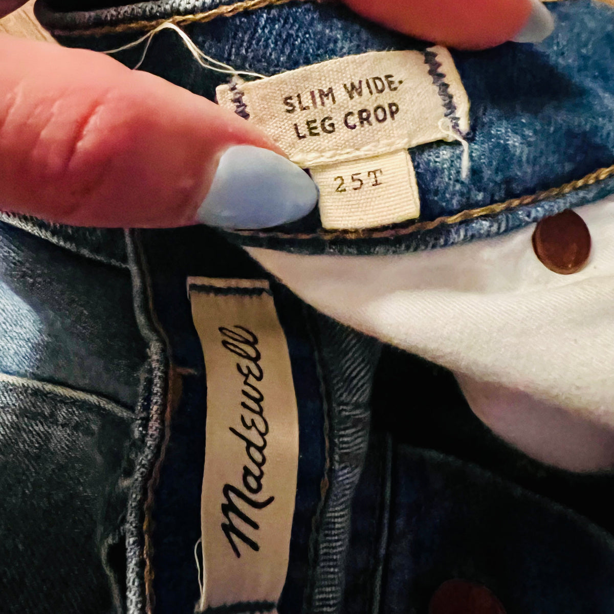 Close-up of a jeans label with 'Madewell' branding and size information.