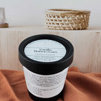 Vanilla butter cream container on a brown surface with a wooden shelf in the background