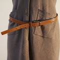 Brown belt worn by a person with a neutral background