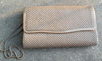 Beige textured clutch bag on a gray surface