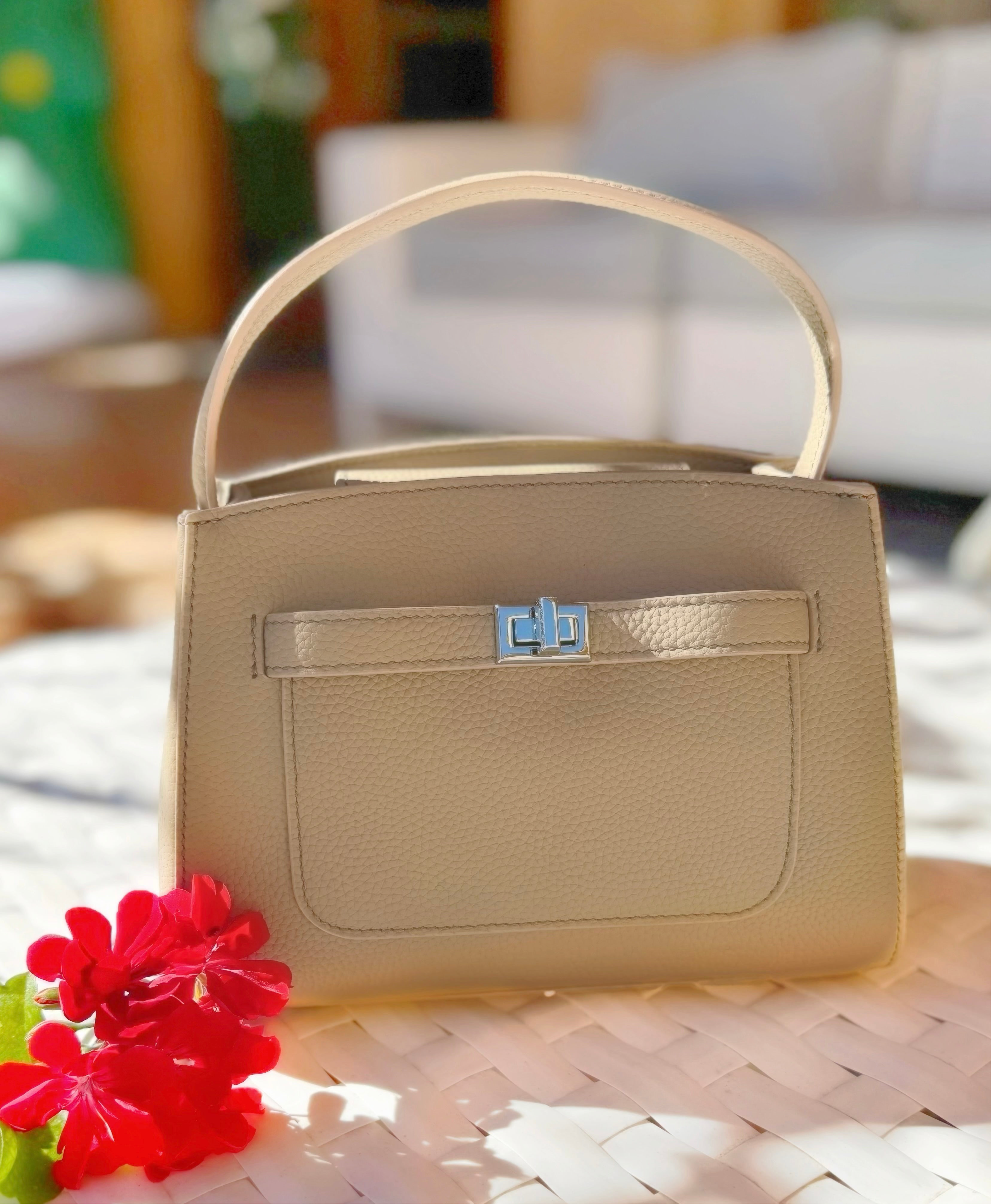 Beige handbag with a blue clasp on a blurred background