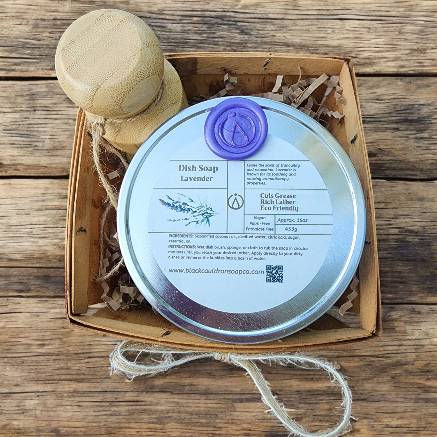 Dish soap bar with wooden handle and packaging on a wooden surface