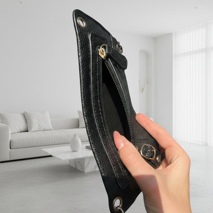 Hand holding a black leather wallet with a blurred background