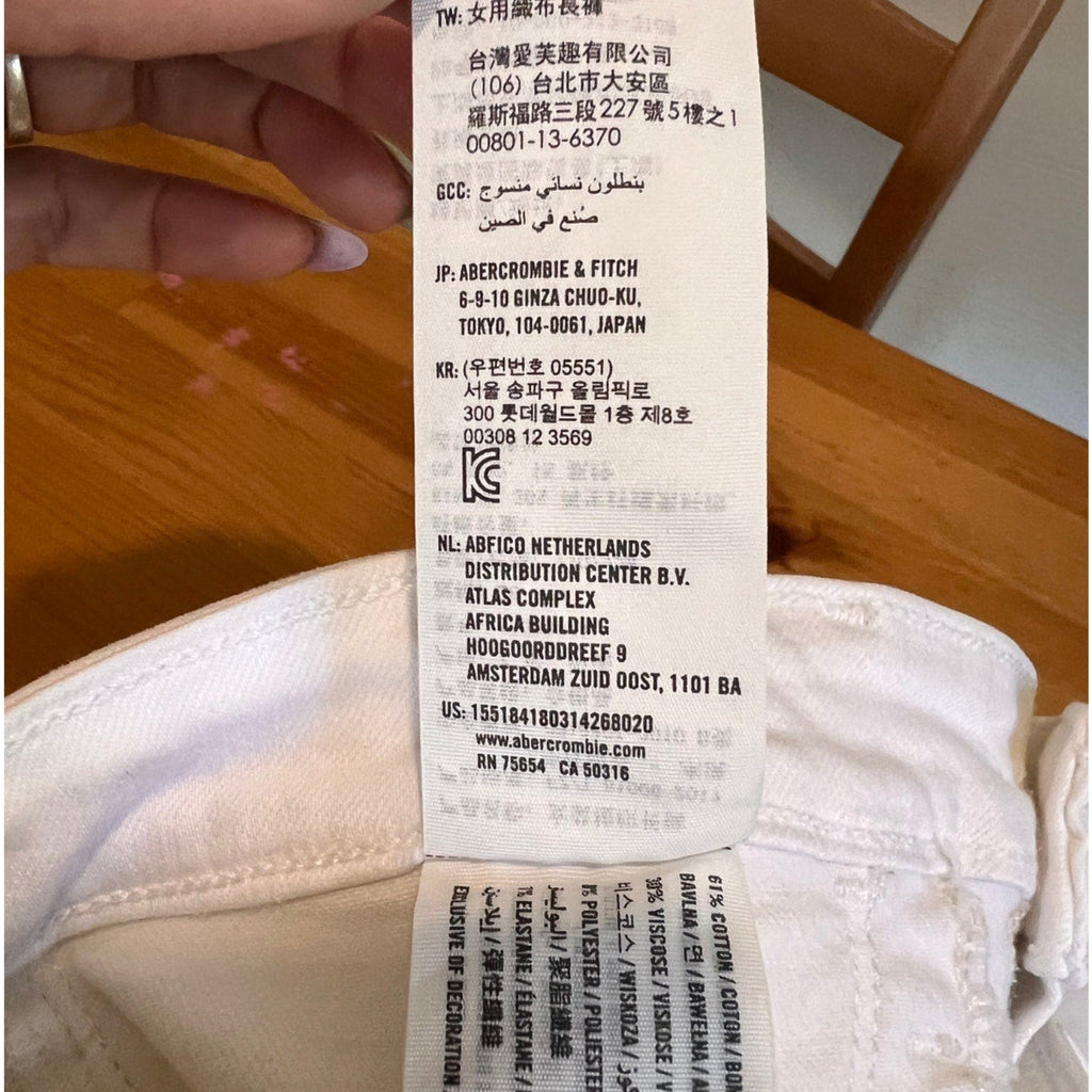 Close-up of a label on a white garment with text and a barcode.
