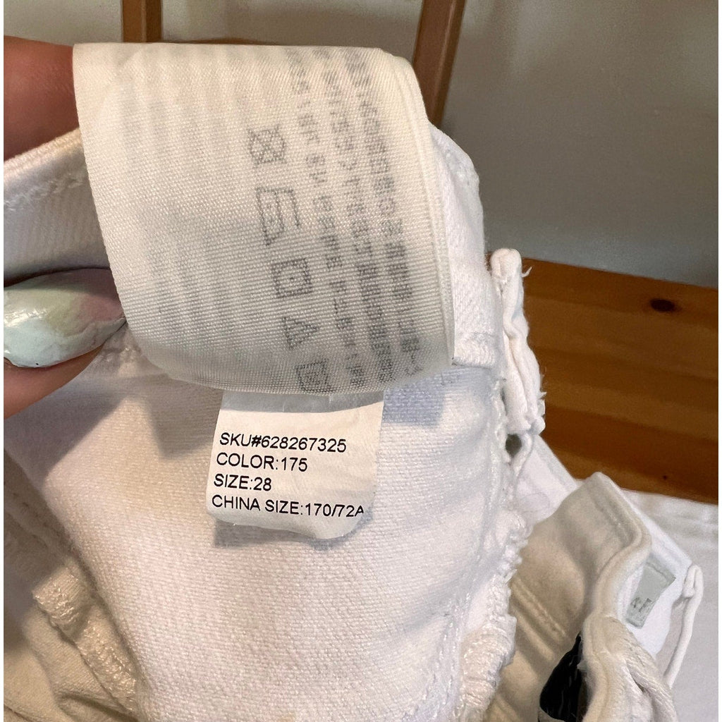 White socks with labels showing size and color information on a wooden surface.