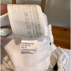 White socks with labels showing size and color information on a wooden surface.
