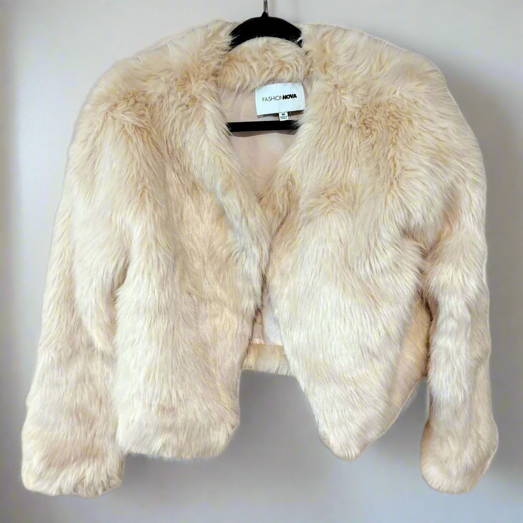Beige faux fur jacket on a hanger with a visible brand label against a white background