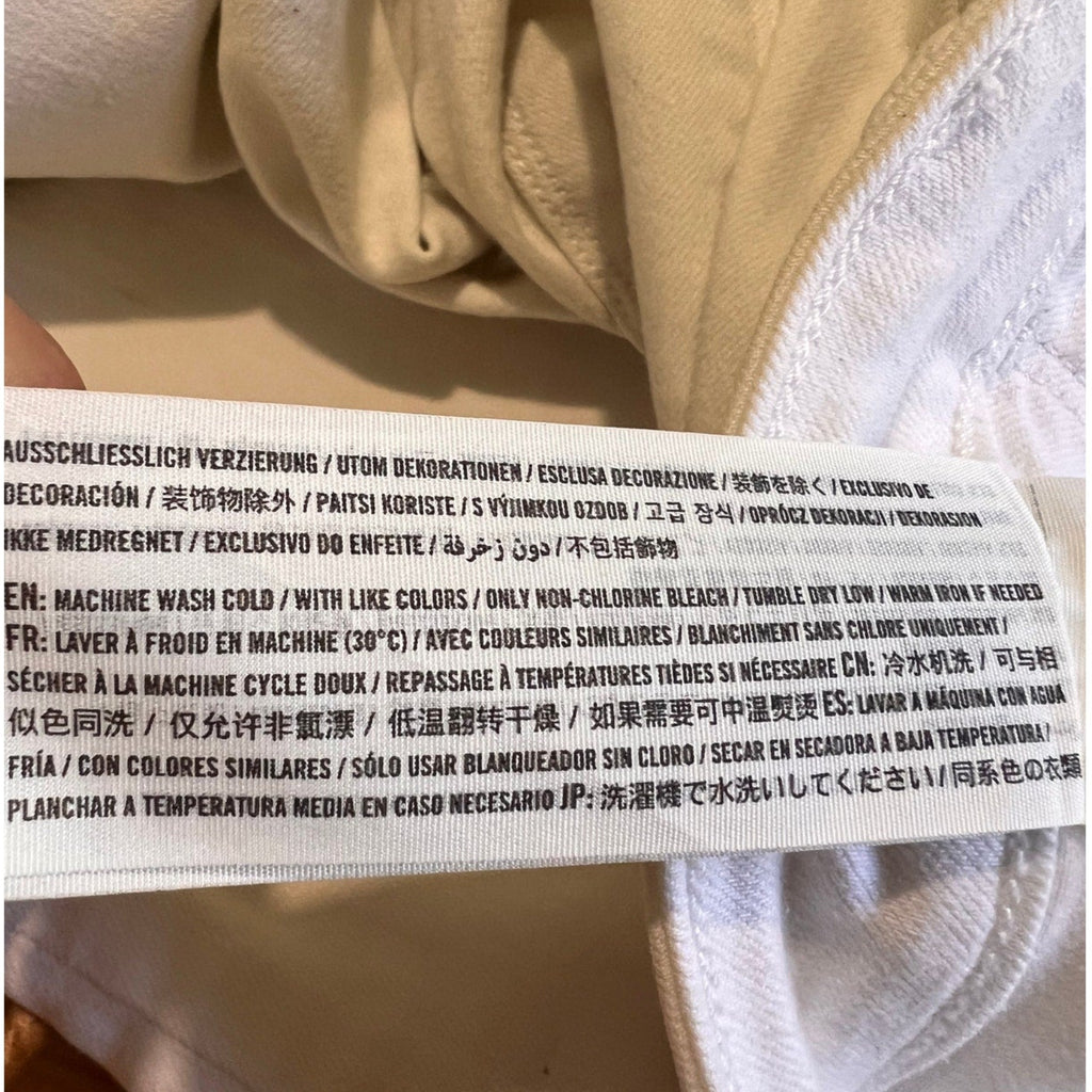 Close-up of a label on a beige garment with text.