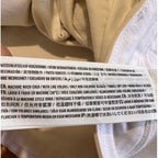 Close-up of a label on a beige garment with text.