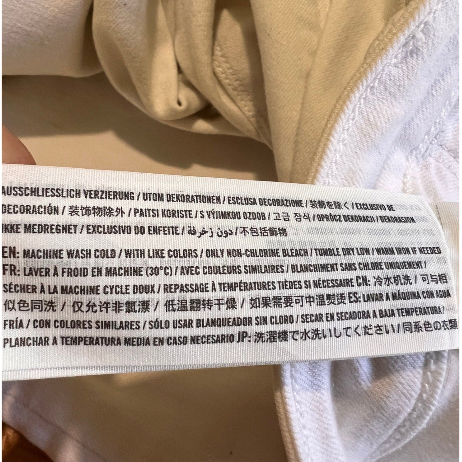 Close-up of a label on a beige garment with text.