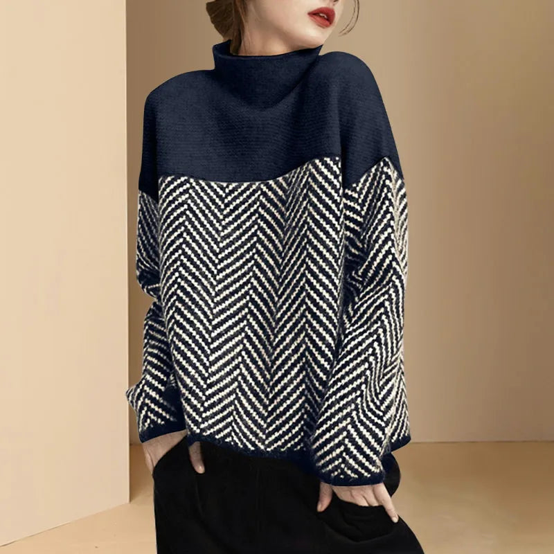 Person wearing a navy and white patterned sweater against a beige background