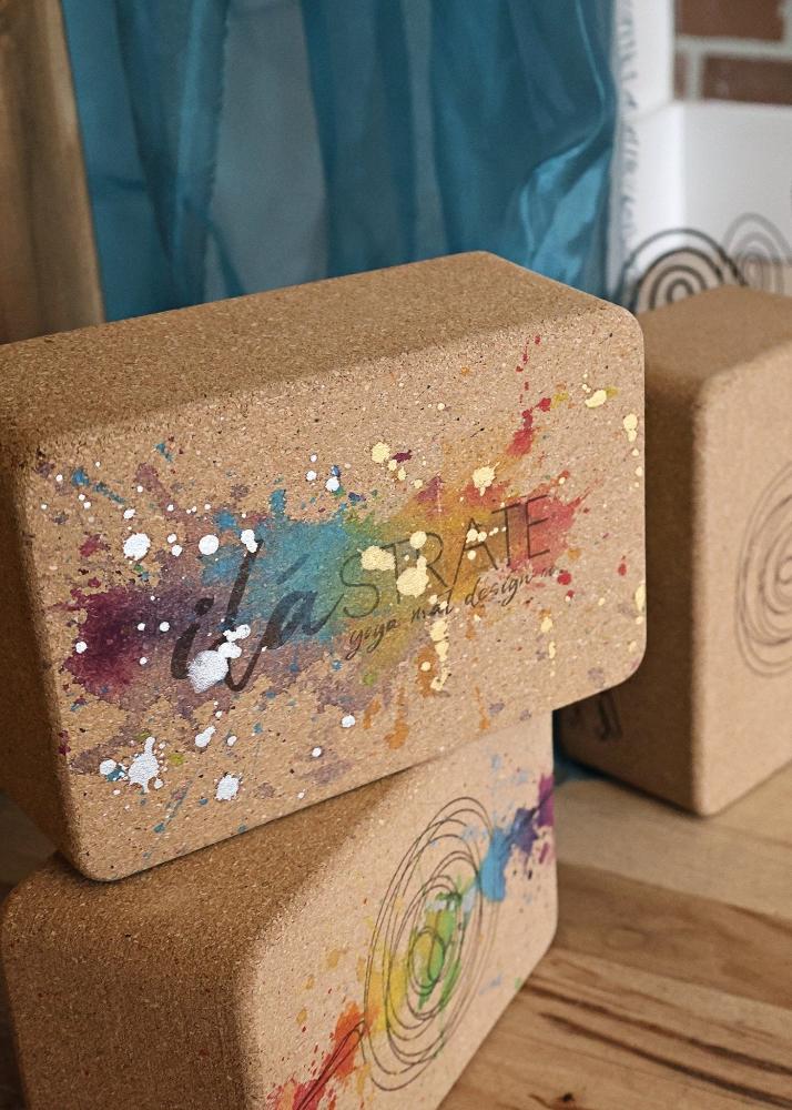 Cork yoga block with colorful paint splashes and 'it's a mine' text on a wooden surface.