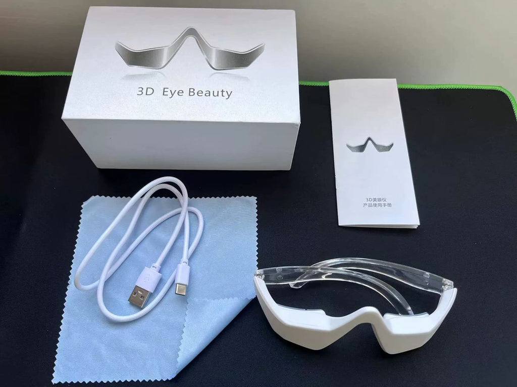 White eye beauty device with USB cable, cleaning cloth, and packaging on a dark surface.